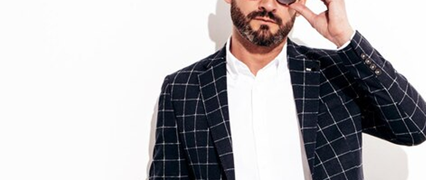 Мужчина с бородой в синем пиджаке и булой рубашке